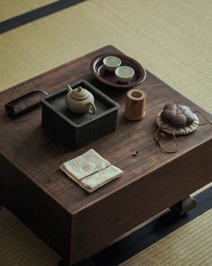 a wooden table topped with tea cups and other items on top of eachother