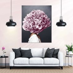 a living room with a white couch and pink flowers on the wall in it's center