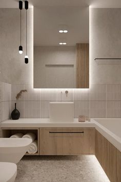 a modern bathroom with two sinks, toilet and bathtub