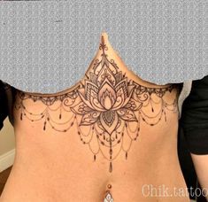 a woman's back with an intricate tattoo on it