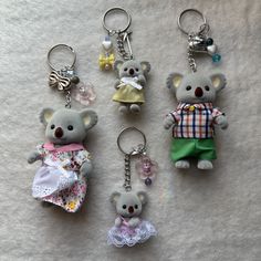 four key chains with teddy bears on them sitting next to each other in different outfits