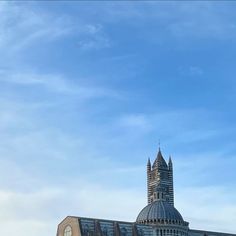 a large building with a clock tower on top and blue sky in the back ground