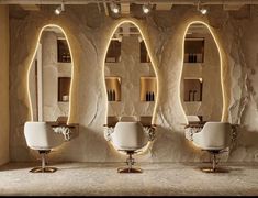 three white chairs sitting in front of a wall with mirrors on it's sides