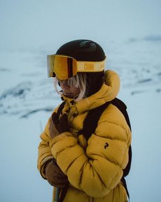 a person wearing a yellow jacket and ski goggles