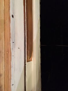 an open door with wood on the side and paint peeling off it's sides