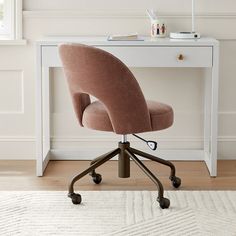 an office chair sitting on top of a wooden floor next to a white desk with drawers