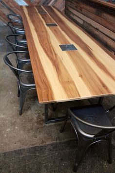 a wooden table sitting next to metal chairs