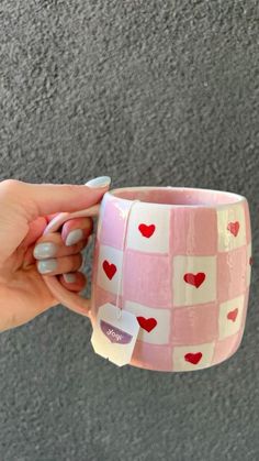 a person holding a cup with hearts on it