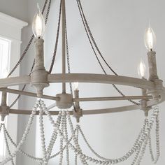 a chandelier with white beads hanging from it's arms and two lights on each end