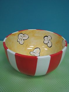 a red and white striped bowl with cartoon mouses on it sitting on a table