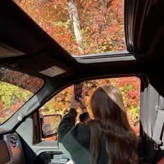 a woman is taking a photo in the car