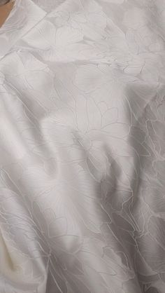 an unmade bed with white sheets and pillows