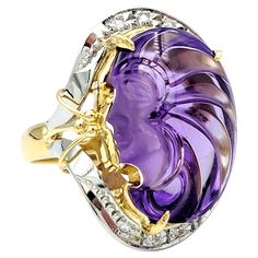 Ring size: 6 This wonderfully unique two-tone carved amethyst cameo ring is an absolute treasure. This piece is a true work of art in both design and craftsmanship, blending timeless beauty with modern luxury. The centerpiece of this ring is a stunning oval-shaped amethyst cameo, expertly carved to showcase intricate details and a delicate profile. The rich purple hue of the amethyst exudes a sense of royalty and charm while also complimenting the warm 18 karat yellow gold setting. To accentuate Luxury Amethyst Diamond Ring In Yellow Gold, Luxury Timeless Oval Amethyst Ring, Luxury Collectible Purple Rings, Collectible Oval Amethyst Ring In Art Deco Style, Collectible Art Deco Purple Rings, Purple Art Deco Collectible Rings, Cameo Ring, Rich Purple, Amethyst Color