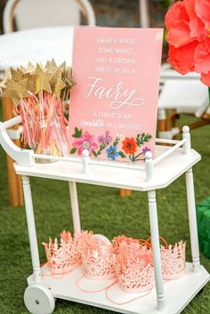 a sign that is sitting on top of a cart with some flowers and candles in front of it