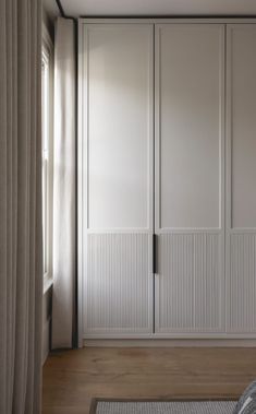 an empty bedroom with white closets and wood flooring