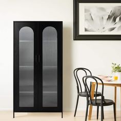 a black cabinet sitting next to a dining room table