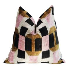 a pink, black and gold pillow on a white background with an abstract design in the middle