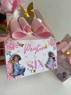 there is a pink bow on top of a card with princesses and stars around it