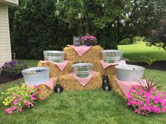 hay bales are stacked on top of each other with pink flowers in the foreground