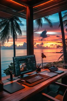 a laptop computer sitting on top of a wooden desk next to a window overlooking the ocean