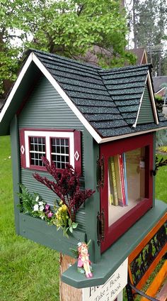 a bird house with flowers and books on it