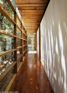 the inside of a house with wood flooring and windows on both sides of it