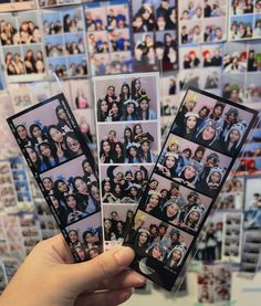 a person holding up several photos in front of a wall full of people's faces