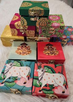 several colorful boxes with designs on them sitting on a white furnishing area next to each other