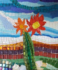 a mosaic wall with flowers on it and blue sky in the backgroung