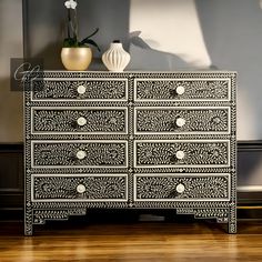 an ornate black and white chest of drawers