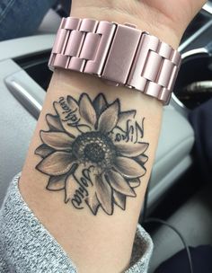 a woman's wrist with a sunflower tattoo on it