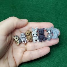 small crocheted animals sitting in the palm of someone's hand