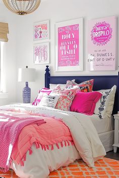 a bedroom decorated in pink and white with pictures on the wall above the headboard