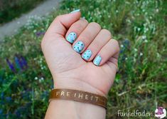 a woman's hand with blue and white polka dots on it, holding up her wrist