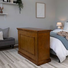 a bed sitting next to a gray couch in a bedroom