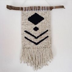 a wall hanging made out of jute and wood with an arrow on the side