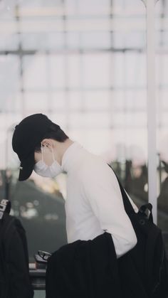 a man wearing a face mask while sitting at an airport