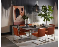 a dining room table with orange chairs and a plant