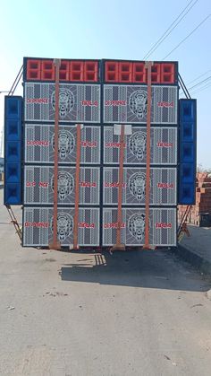 two large blue and red boxes sitting on the back of a truck in a parking lot