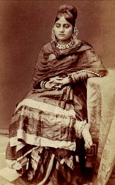 an old photo of a woman sitting on a chair