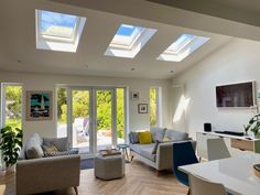 a living room filled with furniture and lots of windows on top of it's walls