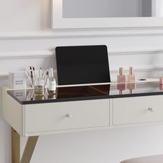 a desk with a laptop on top of it next to a mirror and other items