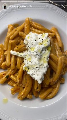 a white plate topped with pasta covered in sauce and an egg on top of it