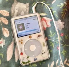 an ipod sitting on top of a floral blanket