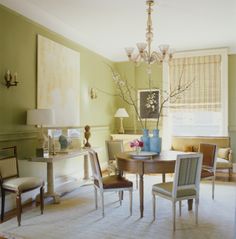 a living room filled with furniture and a chandelier hanging from the ceiling over a table