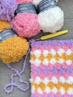 several crocheted teddy bears sitting next to each other on the ground with yarn