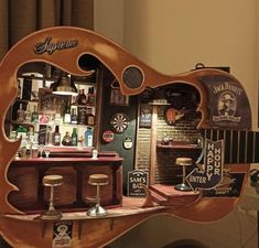 a wooden guitar shaped like a bar with liquor bottles on the shelves and other items around it