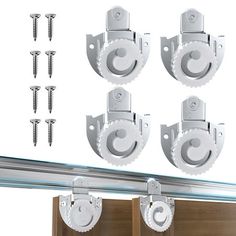 four white brackets with screws on each side and several other hardware pieces in the background