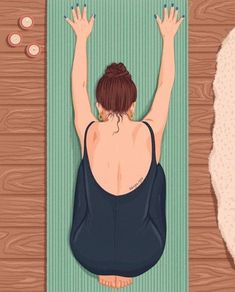 a woman is sitting on a yoga mat with her hands in the air