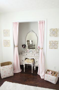 a white dresser sitting under a mirror next to a pink curtained window sill